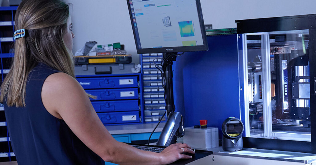 alt=young woman looking at Liminal's battery cycle life prediction insights using their EchoStat platform in the background